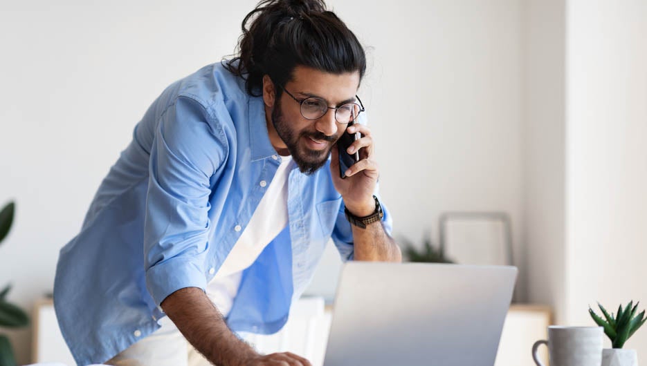 Western Male Entrepreneur Talking On Cellphone And Working On La